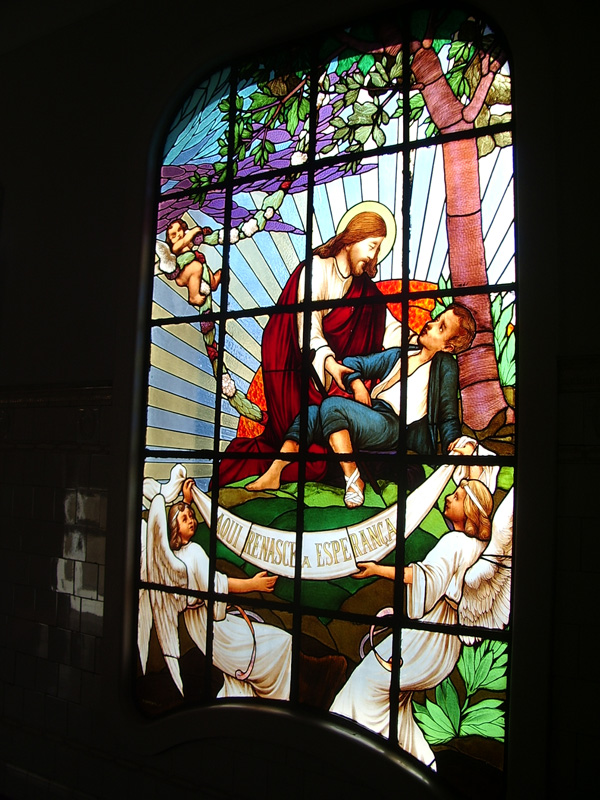 Stained glass window depicting Christ bringing hope to the leprosy affected